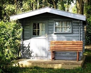 a grey garden shed with a brown wooden garden shed outside