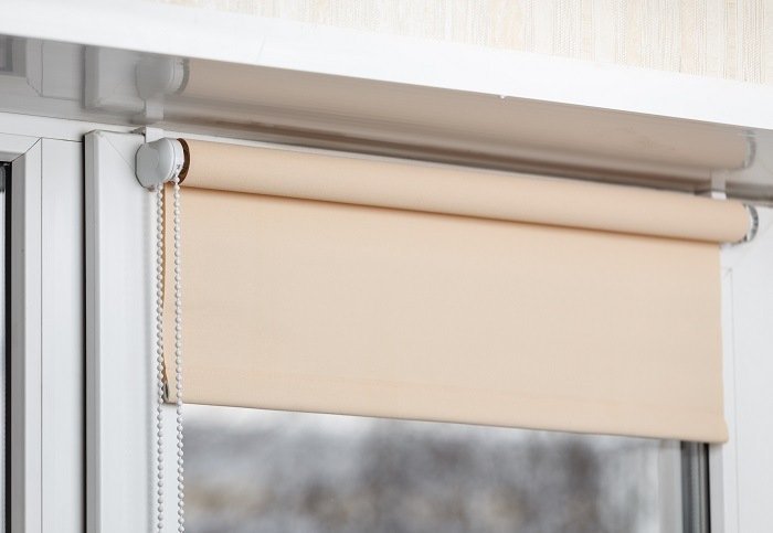 a Beige roller blind partially rolled down