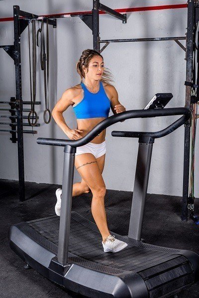lady in sports wear running on curved treadmill