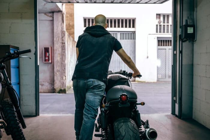 garage door open as man with motorbike leaves
