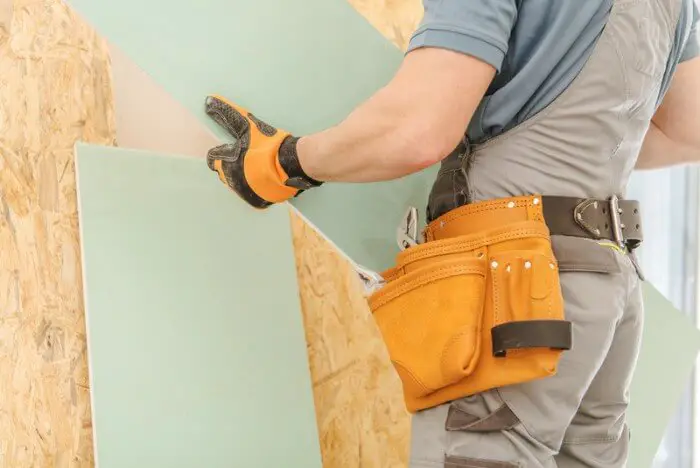 worker fitting drywall